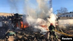 Un bombero trabaja en un sitio de un mercado atacado por misiles rusos, en medio del ataque de Rusia a Ucrania, en la ciudad de Shevchenkove, región de Kharkiv, Ucrania, 9 de enero de 2023. (Gobernador de la región de Kharkiv, Oleh Sunehubov vía Telegram/Handout vía Reuters)