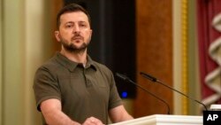 FILE - Ukrainian President Volodymyr Zelenskyy stands at the podium during a news conference in Kyiv, July 3, 2022. 