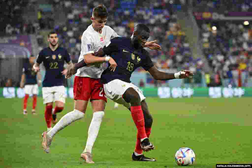 Defesa da Dinamarca, Pierre-Emile Hojbjerg (e) disputa a bola com defesa de França Dayot Upamecano em jogo do grupo D, Stadium 974, Doha. Nov 26