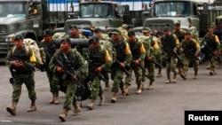 Soldados marchan para abordar un avión a la península de Baja California después de que el huracán Odile azotara la zona, dentro del hangar de la Secretaría de la Defensa Nacional (SEDENA) en la Ciudad de México el 17 de septiembre de 2014.