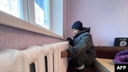 This undated handout photograph released on Dec. 9, 2022 by Kazakhstan's government press service shows a worker repairing radiators in an apartment in Ekibastuz.