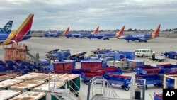 Southwest Airlines jets are seen at the John Wayne Airport in Santa Ana, Calif., Dec. 27, 2022. Southwest Airlines scrubbed thousands of flights Tuesday in the aftermath of the massive winter storm that wrecked Christmas travel plans across the U.S.