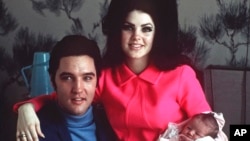 FILE - Elvis Presley da matarsa Priscilla da diyarsa Lisa Marie, a daki a asibitin Baptist a Memphis, Tenn., Feb. 5, 1968.