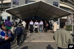 北京清华大学的学生手举白纸抗议严厉的防疫政策，悼念日前在新疆乌鲁木齐市死于火灾的至少10名遇难者。 （2022年11月27日）