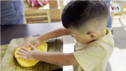 Niños aprenden a hacer hallacas, el plato típico de navidad en Venezuela