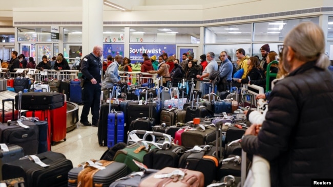 Southwest Airlines travelers wait in line to check on their baggage from their canceled flights at Chicago's Midway International Airport, Dec. 27, 2022.