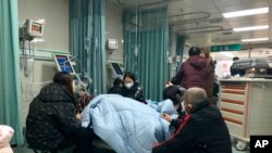Relatives gather near the bed of a patient at the emergency department of the Langfang No. 4 People's Hospital in Bazhou city in northern China's Hebei province, Dec. 22, 2022. 