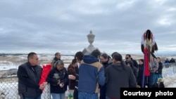 Oglala Lakota president Frank Star Comes Out (L), holding the tribe's canupa (pipe), joins Lakota gathered at Wounded Knee Cemetery to honor massacre victims, Dec. 29, 2022. Courtesy Frank Star Comes Out.