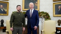 FILE- President Joe Biden poses for a photo with Ukrainian President Volodymyr Zelenskyy in the Oval Office of the White House, in Washington, Dec. 21, 2022.