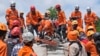 Rescuers use a saw as they try to recover the body of an earthquake victim from under the rubble of a collapsed building in Cianjur, West Java, Indonesia, Nov. 22, 2022. 