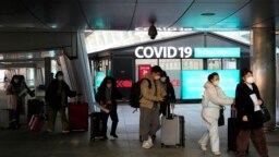 Passengers arriving from China pass by a COVID-19 testing center at the Incheon International Airport In Incheon, South Korea, Jan. 10, 2023.