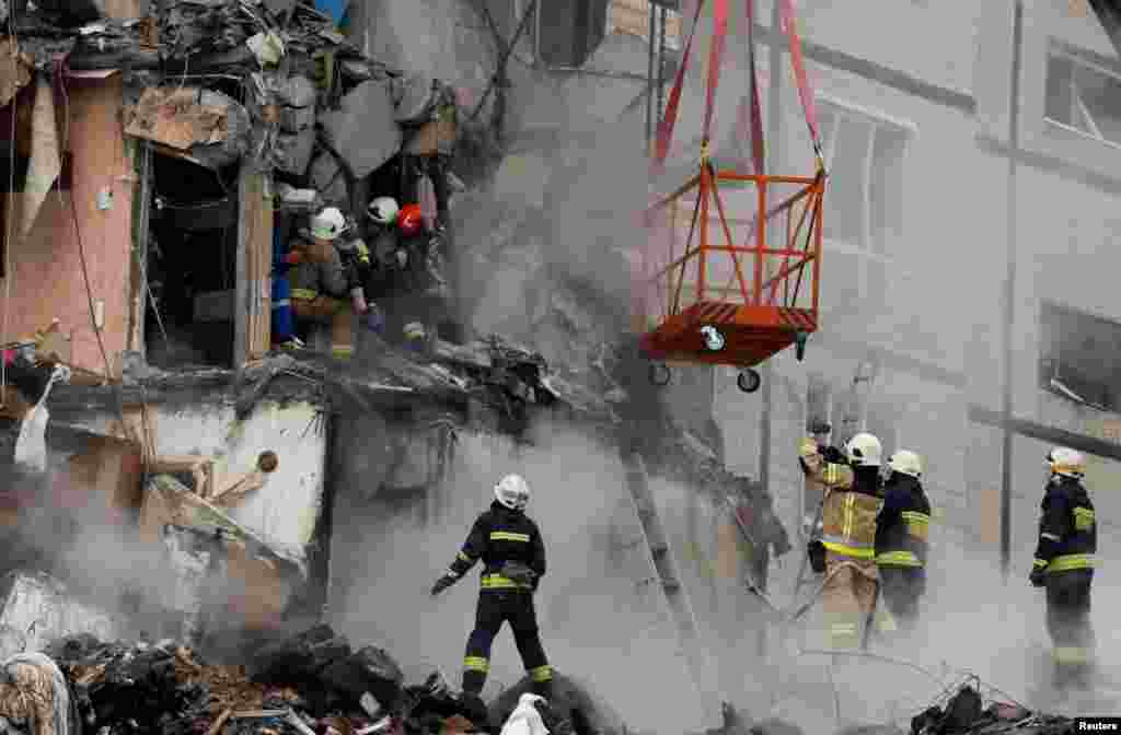 Emergency personnel evacuate a woman at the site where an apartment block was heavily damaged by a Russian missile strike in Dnipro, Ukraine.