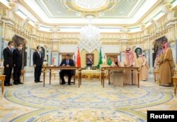 Raja Saudi Salman bin Abdulaziz dan Presiden China Xi Jinping menandatangani dokumen selama pertemuan di Riyadh, Arab Saudi 8 Desember 2022. (Bandar Algaloud/Courtesy of Saudi Royal Court/Handout via REUTERS)