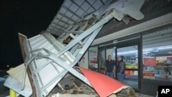 Un empleado de Winn-Dixie habla con un cliente y le dice que la tienda está cerrada después de que la fachada se derrumbara debido a un tornado en Gretna, Louisiana, en la parroquia de Jefferson, vecina de Nueva Orleans, el miércoles 14 de diciembre de 2022. Nadie resultó herido. en la tienda. (Foto AP/Matthew Hinton)