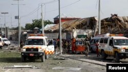 FILE - Somali police and paramedics are seen at the scene after a car exploded in a suicide attack near Mucassar primary and secondary school in Hodan district of Mogadishu, Somalia Nov. 25, 2021.