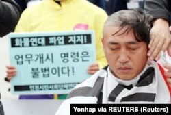 Seorang pengemudi truk mencukur rambutnya sebagai bagian dari protes terhadap Presiden Yoon Suk-yeol yang mengeluarkan perintah agar mereka kembali bekerja di Incheon, Korea Selatan, 29 November 2022. (Foto: Yonhap via REUTERS)