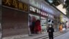 Seorang warga tampak berjalan melewati barisan toko-toko, sebagian di antaranya masih tutup, di Wuhan, China, pada 10 Desember 2022, setelah pemerintah China melonggarkan pembatasan terkait COVID-19. (Foto: Reuters/Martin Pollard)