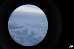 The frozen tundra of northern Alaska is seen out a window of an Alaska National Guard cargo plane en route to Nuiqsut, Alaska, Nov. 29, 2022.