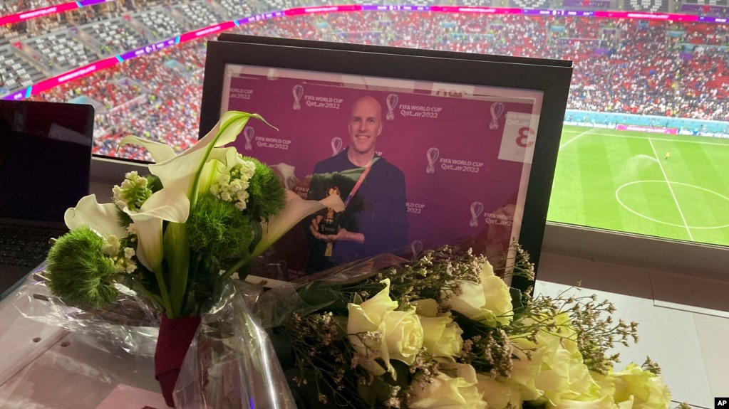 2022年12月10日，在卡塔尔阿尔霍尔的体育场举行的英格兰和法国世界杯四分之一决赛足球比赛中，人们在格兰特·瓦尔之前被指定的座位上摆放鲜花和照片表达对他的致敬。（美联社照片）(photo:VOA)
