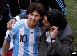 Legenda sepak bola Argentina Diego Maradona, kanan, melatih Lionel Messi pada Piala Dunia di Johannesburg, Afrika Selatan, 17 Juni 2010. (Foto: AP)