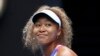 Naomi Osaka dari Jepang tersenyum saat pertandingan putaran pertama melawan Camila Osorio dari Kolombia di kejuaraan tenis Australia Terbuka di Melbourne, Australia, Senin, 17 Januari 2022. (Foto: AP)