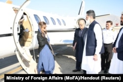 Pakistan's Minister of State Hina Rabbani Khar, left, greets Ubaid-ur-Rahman Nizamani, head of Mission of Embassy of Pakistan, right, upon her arrival in Kabul, Afghanistan, Nov. 29, 2022.