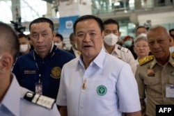 Thai Health Minister Anutin Charnvirakul, center, walks with officials at Suvarnabhumi Airport in Bangkok, Jan. 9, 2023.