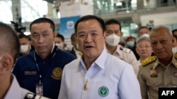 Thai Health Minister Anutin Charnvirakul, center, walks with officials at Suvarnabhumi Airport in Bangkok, Jan. 9, 2023.