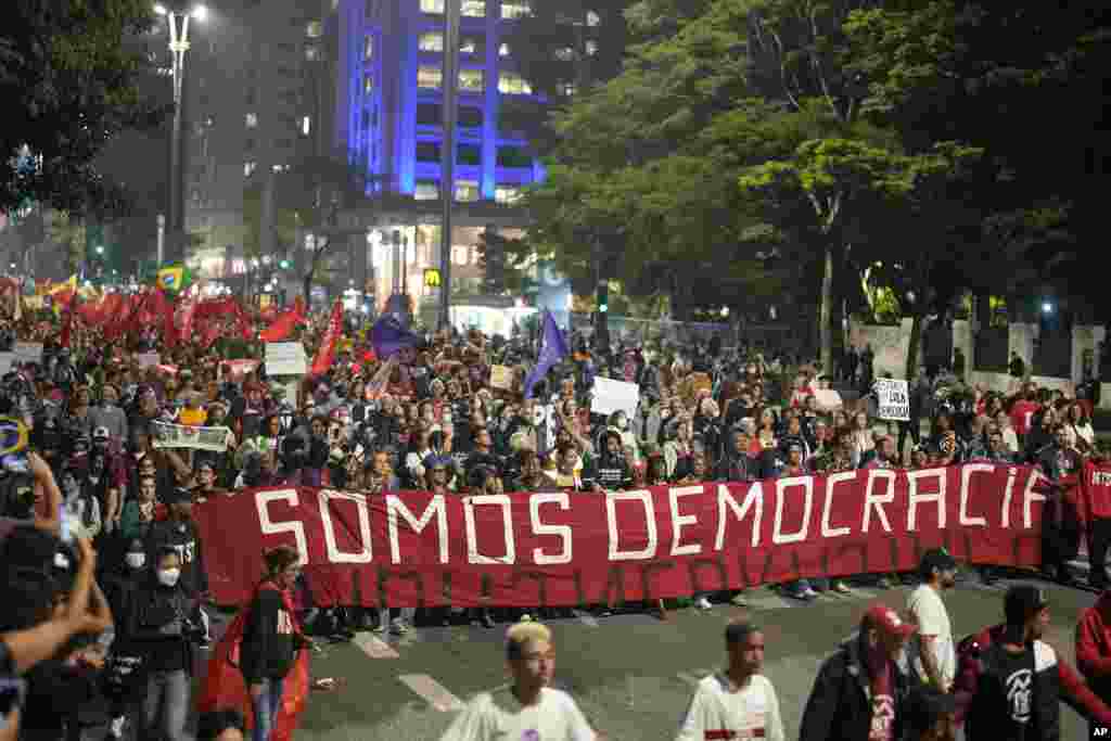 Demonstrators march holding a banner that reads in Portuguese, &quot;We are Democracy,&quot; during a protest calling for protection of the nation&#39;s democracy in Sao Paulo, Brazil, Jan. 9, 2023,&nbsp;a day after supporters of former President Jair Bolsonaro stormed government buildings in the capital.