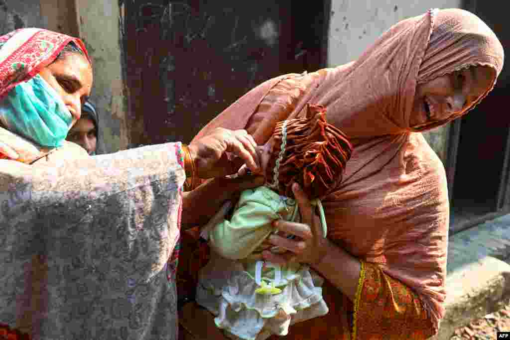 A health worker administers polio vaccine drops to a child during a vaccination campaign in Lahore, Pakistan.