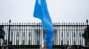 FILE - A man holds the Uyghur flag on Pennsylvania Avenue in front of the White House during a protest last year against the Chinese Communist Party. 