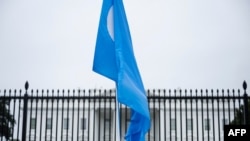 FILE - A Uyghur flag is held high on Pennsylvania Avenue in front of the White House during a protest against the Chinese Communist Party, Oct. 1, 2022.