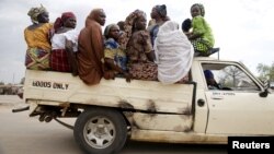 FILE - Women travel in the back of a truck in the town of Mararaba after the Nigerian military recaptured it from Boko Haram, in Adamawa state, May 10, 2015.