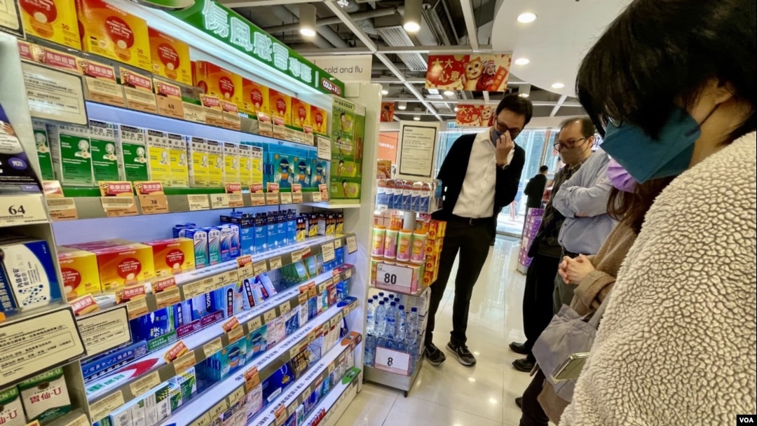 香港一间连锁药房的感冒止痛药货架前,聚集多名顾客围观,等待含扑热息痛的防疫药物上架 (美国之音/汤惠芸)
