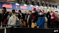 Passengers line up to go through security at Detroit Metro Airport in Romulus, Michigan, December 22, 2022. Forecasts of a severe winter storm threatened to wreak havoc on vacation travel plans for millions of Americans.