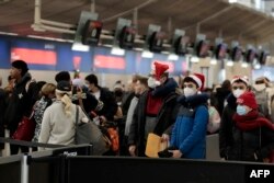 Penumpang antre di Bandara Metro Detroit di Romulus, Michigan, 22 Desember 2022. (JEFF KOWALSKY / AFP)