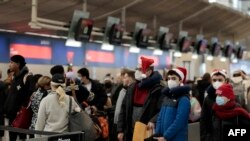 Sejumlah penumpang tampak mengantre untuk melewati pemeriksaan di Bandara Metro Detroit Metro di Romulus, Michigan, pada 22 Desember 2022. (Foto: AFP/Jeff Kowalsky)