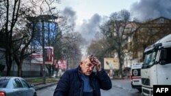 Povrijeđeni muškarac stoji na ulici nakon ruskog granatiranja ukrajinskog grada Hersona, 24. decembra 2022. godine. 