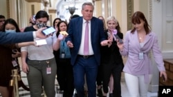 ARCHIVO - El líder republicano de la Cámara de Representantes, Kevin McCarthy, se apresura a llegar a su oficina con los reporteros que lo persiguen en el Capitolio en Washington, el 12 de mayo de 2022.