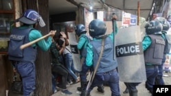 FILE - Police strike Bangladesh Nationalist Party (BNP) activists with batons as they gather in front of the party's central office in Dhaka, Bangladesh, Dec. 7, 2022.