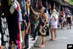 Turis asing berbelanja oleh-oleh di Bali, Sabtu, 12 November 2022. (AP/Firdia Lisnawati)