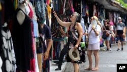 Turis asing berbelanja oleh-oleh di Bali, pada Sabtu, 12 November 2022. (Foto: AP)