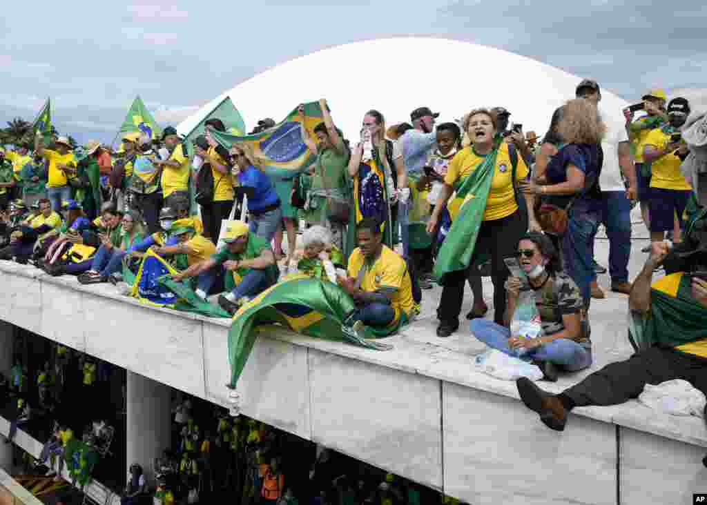 Manifestantes, simpatizantes del expresidente brasileño Jair Bolsonaro, se pararon en el techo del edificio del Congreso Nacional después de que lo asaltaron, en Brasilia, el domingo 8 de enero de 2023.&nbsp;