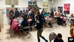 Migrants line up for meals at El Buen Samaritano shelter in Ciudad Juarez, Mexico, Dec. 20, 2022. Many are waiting for appointments to cross into the U.S. and request asylum.