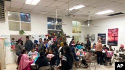 Para migran antre untuk makan di tempat penampungan migran "El Buen Samaritano" di Juarez, Meksiko. Mereka menunggu janji untuk menyeberang ke AS dan meminta suaka.