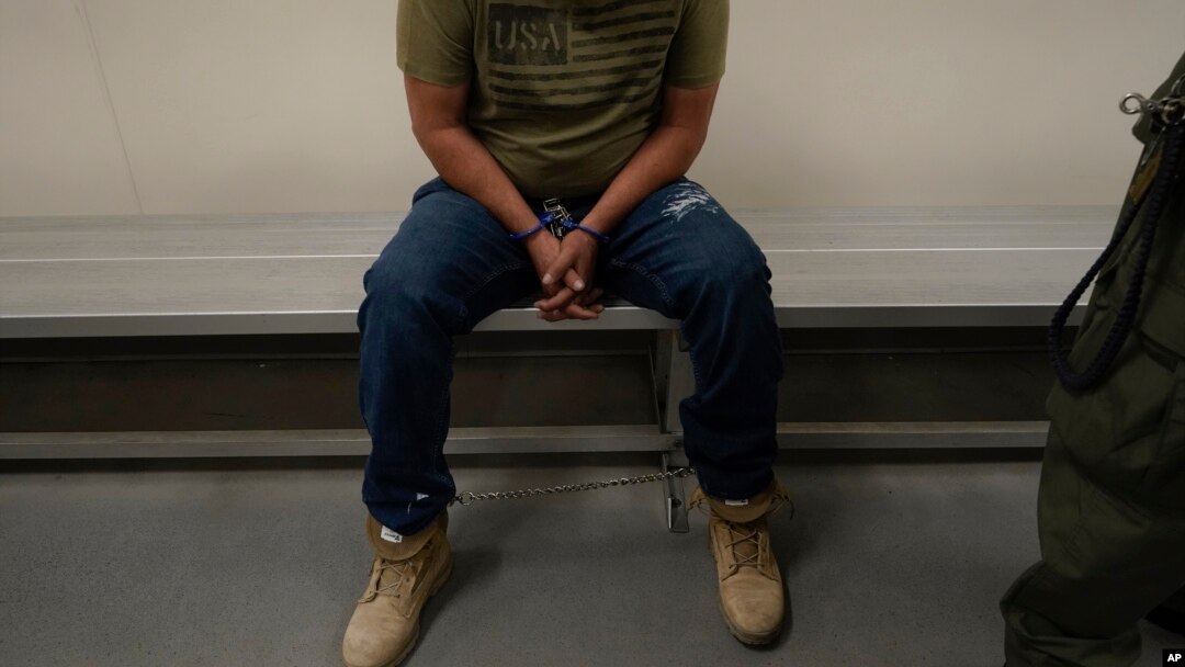 FILE - An immigrant considered a threat to public safety and national security waits to be processed by U.S. Immigration and Customs Enforcement agents at the ICE Metropolitan Detention Center in Los Angeles, after an early morning raid, June 6, 2022.