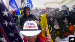 FILE - People loyal to then-President Donald Trump try to break through a police barrier Jan. 6, 2021, at the Capitol in Washington.