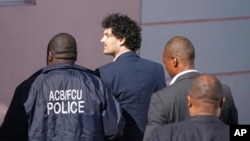 FTX founder Sam Bankman-Fried, center, arrives at the Magistrate Court building for a hearing, in Nassau, Bahamas, Dec. 21, 2022.
