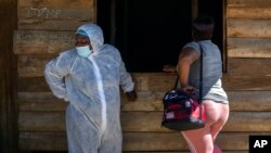 FILE - A nurse stands next to a sex worker outside a mobile HIV clinic in Ngodwana, South Africa. Taken Thursday, July 2, 2020.