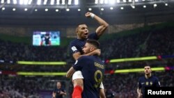 France's Olivier Giroud celebrates scoring their first goal with teammate Kylian Mbappe at the World Cup Qatar Round of 16 match on December 4, 2022
